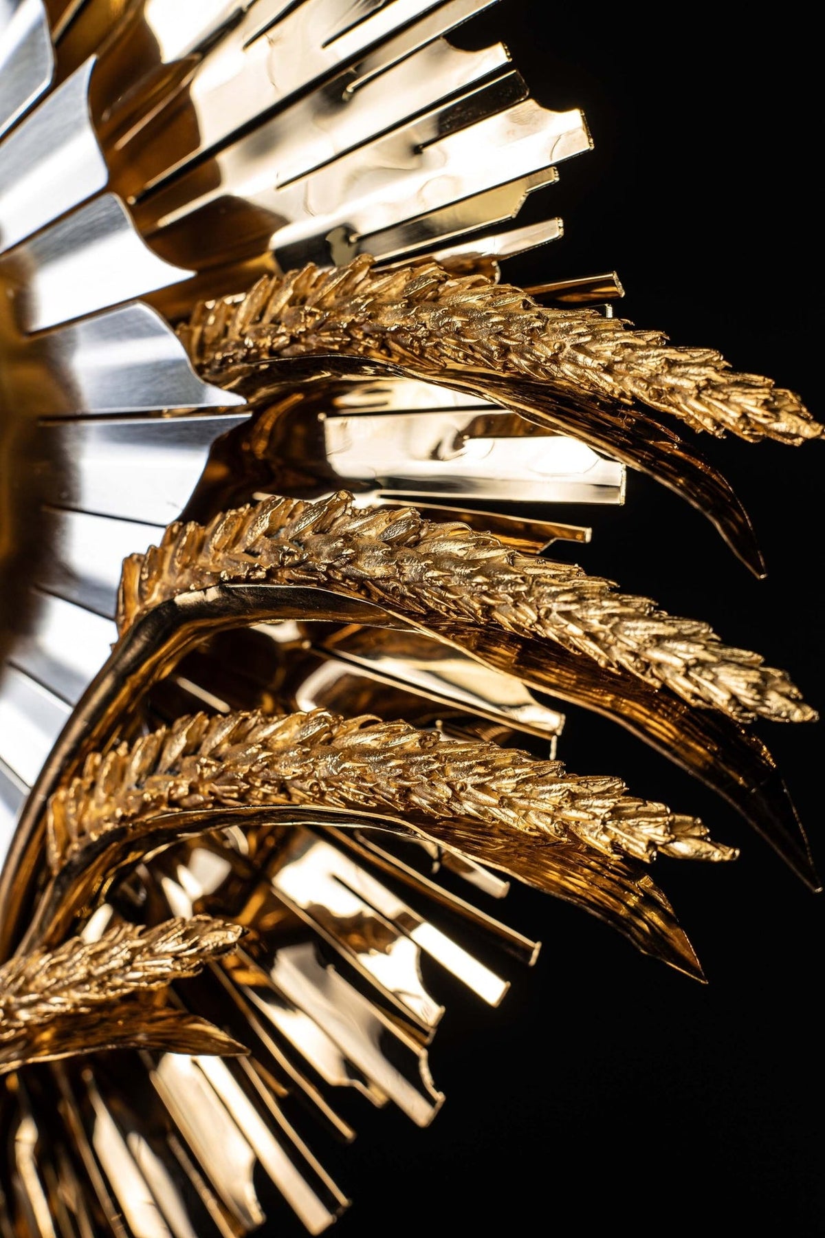 Gold-plated brass monstrance side close-up showing ruby settings and silver-toned rays