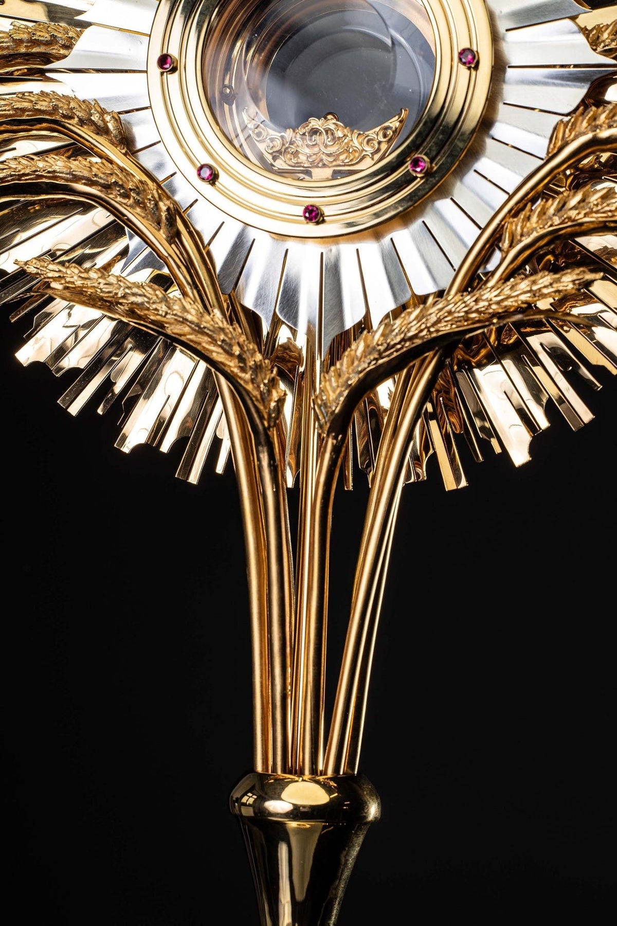 Gold-plated brass monstrance close-up of sculpted wheat motifs and radiating rays