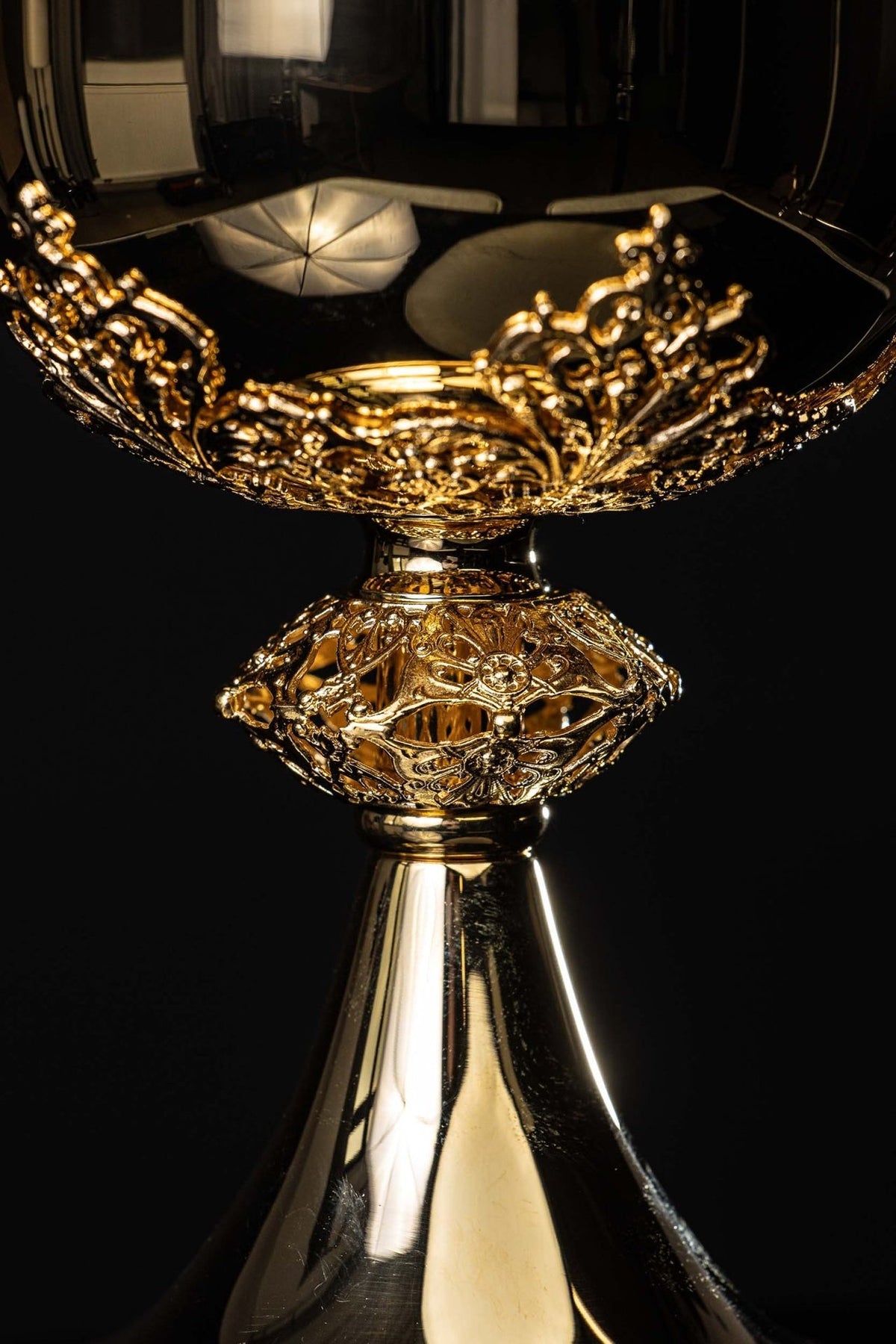 Gold-plated brass ciborium close-up of ornate relief around the bowl and openwork stem
