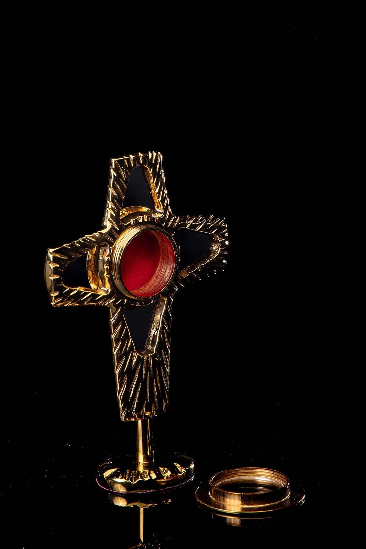 Gilded brass reliquary, angled view showing red center and removable circular front piece