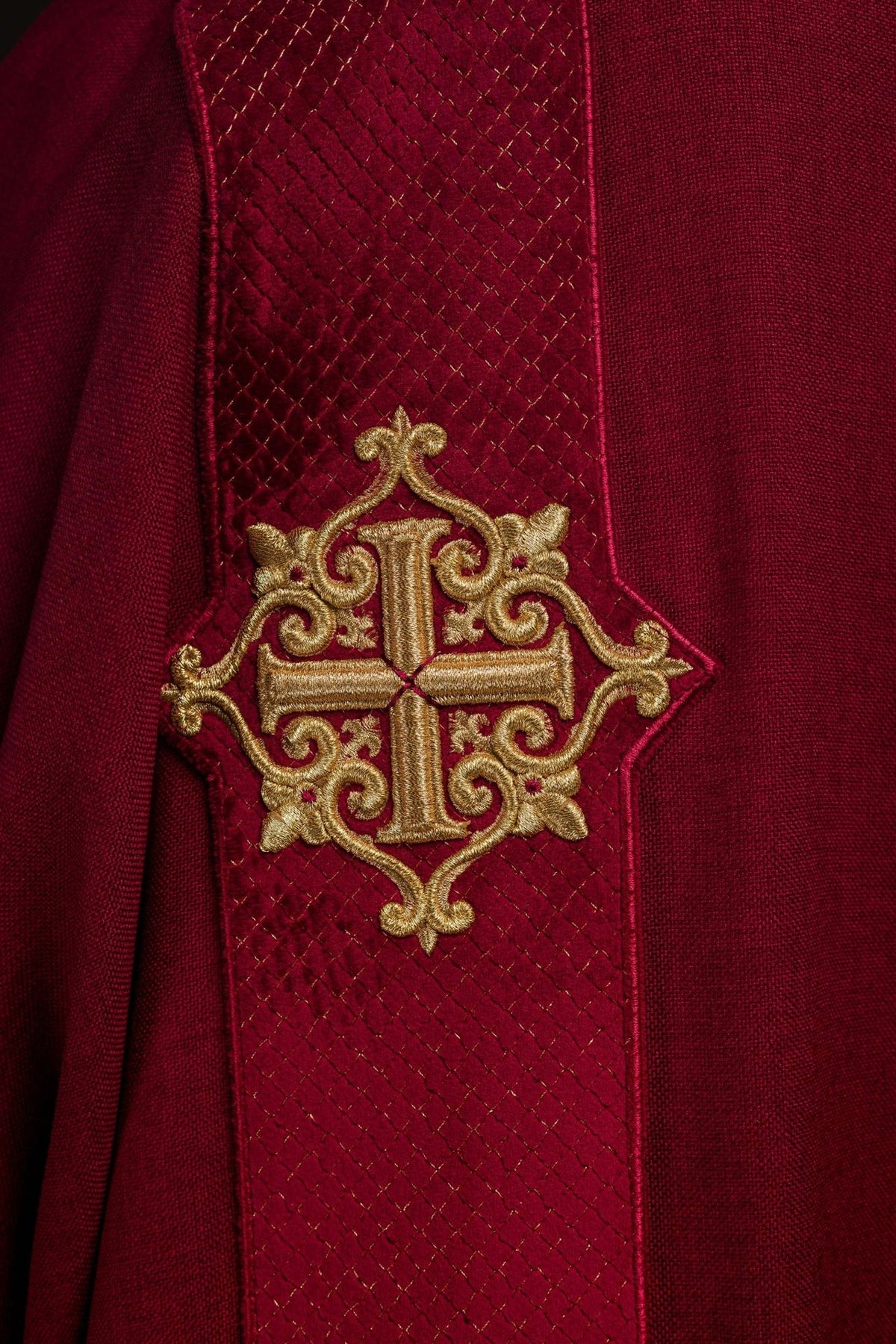 Red dalmatic sleeve detail with velvet fabric, satin trim and gold cross embroidery