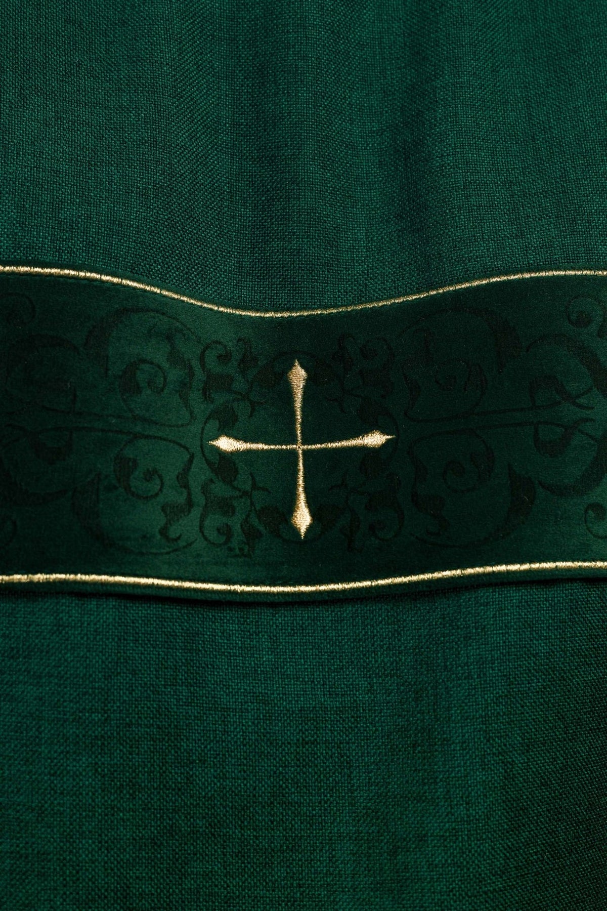 Green dalmatic close-up of embroidered gold cross on velvet trim