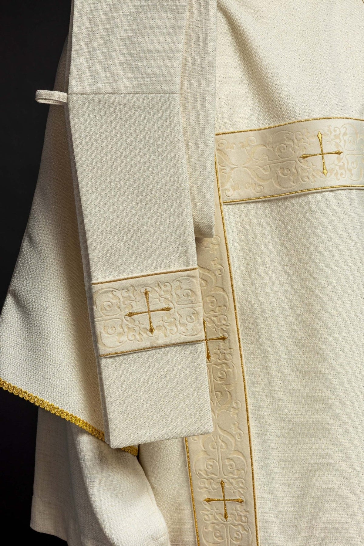Ecru dalmatic side detail showing velvet orphrey, gold trim and cross embroidery