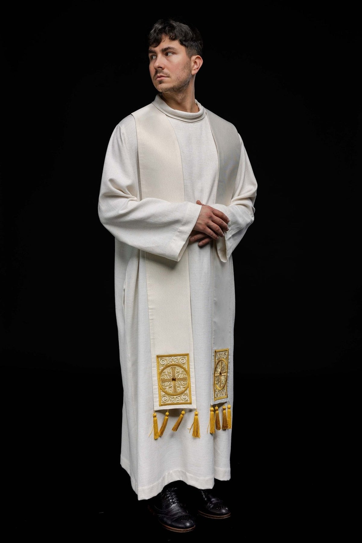 Priest stole worn in a white and gold front three-quarter view with embroidered crosses and tassels