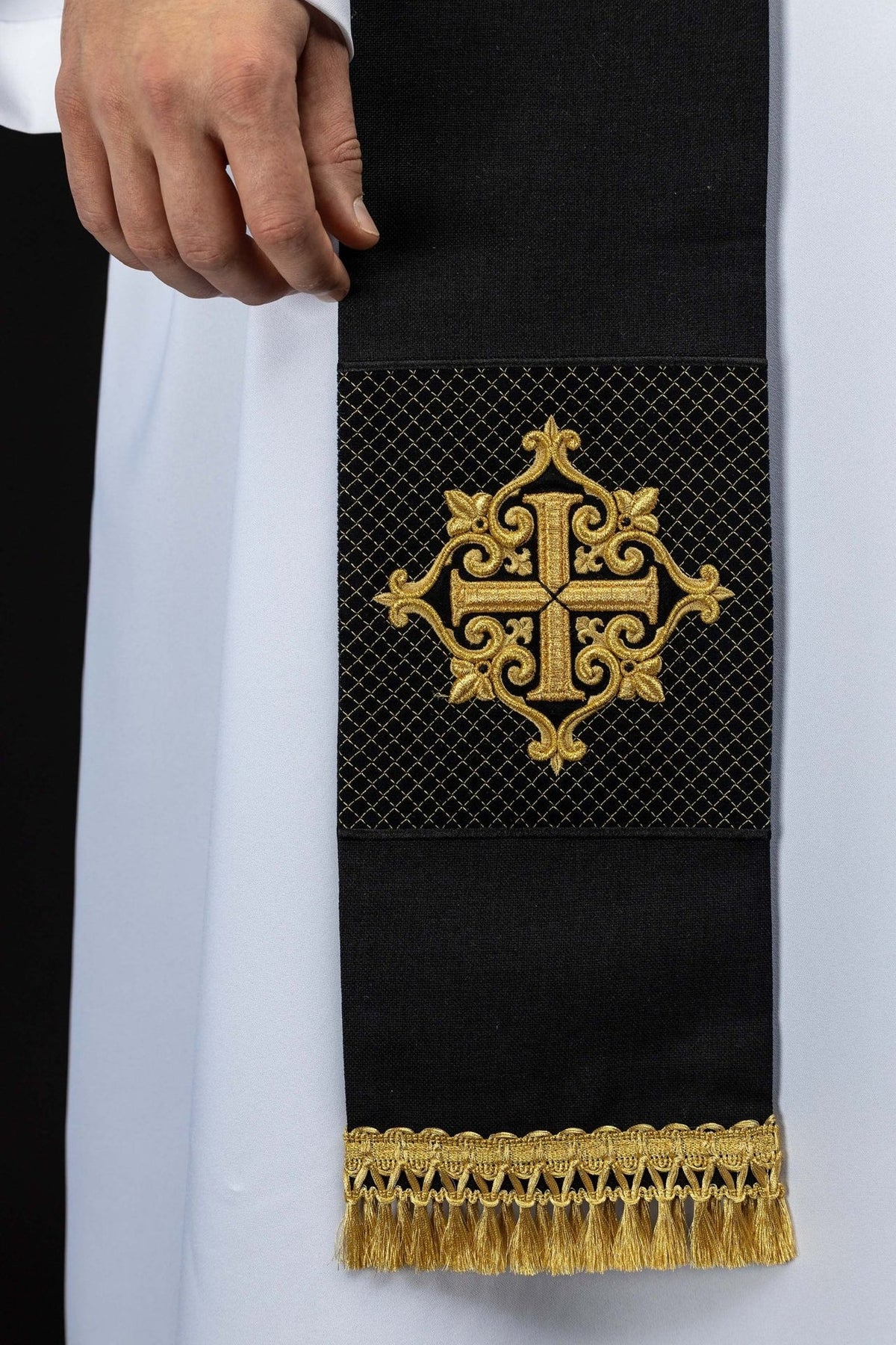 Black velvet priest stole close-up with gold embroidered cross and fringe