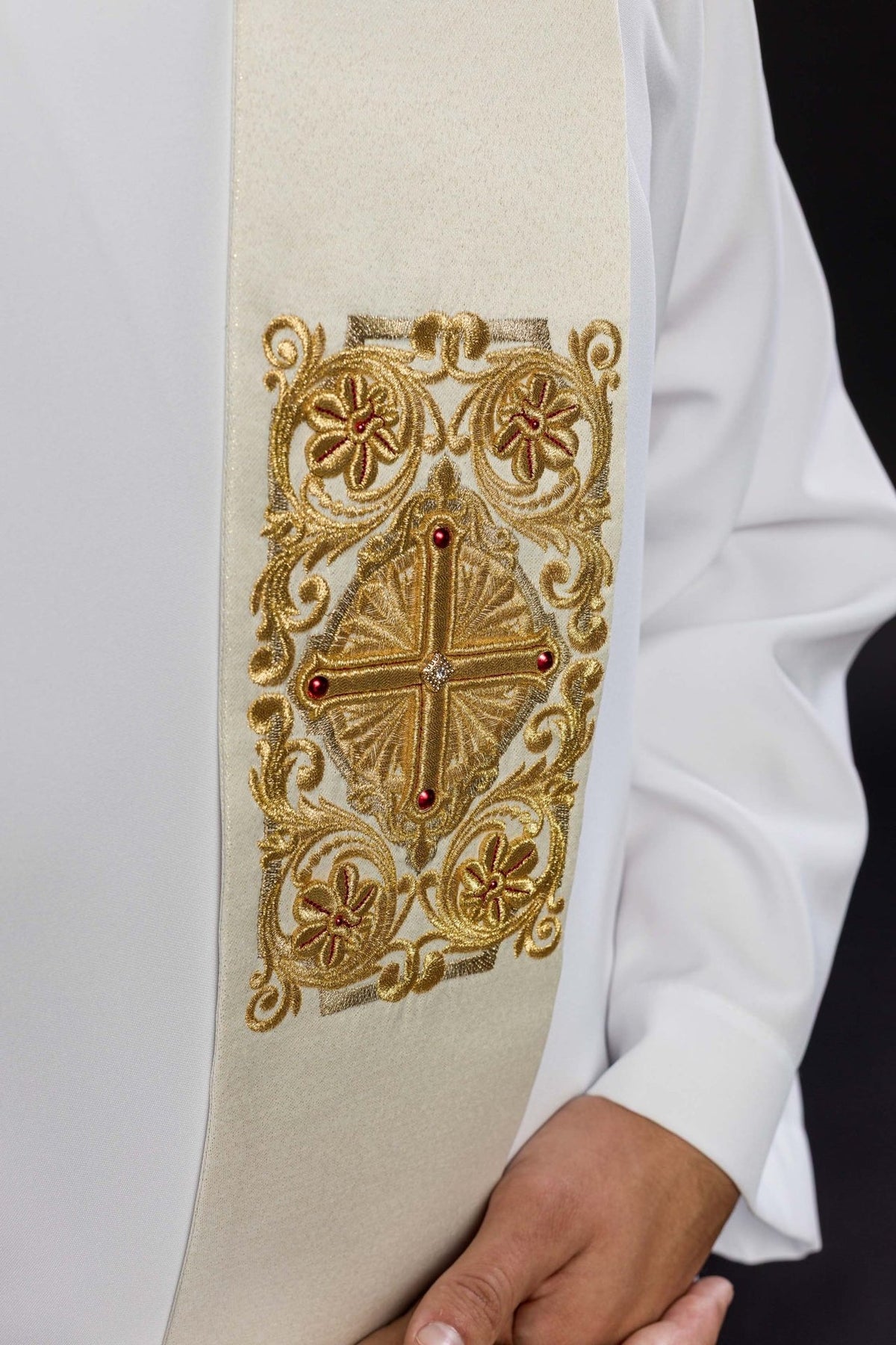 Embroidered stole close-up showing ornate gold cross and floral embroidery