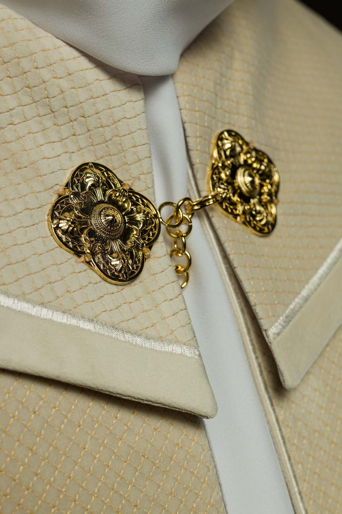 Cope close-up showing ecru velvet orphrey, gold grid embroidery and ornate clasp