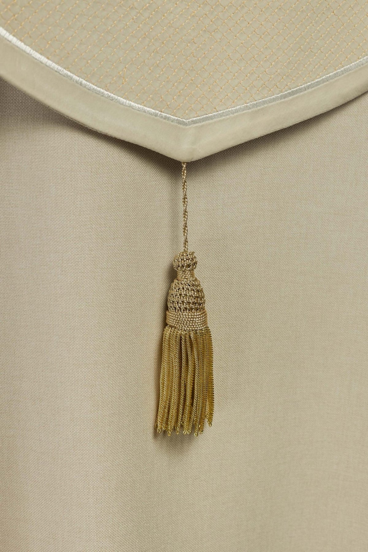 Cope detail showing pointed ecru velvet orphrey edge and gold tassel
