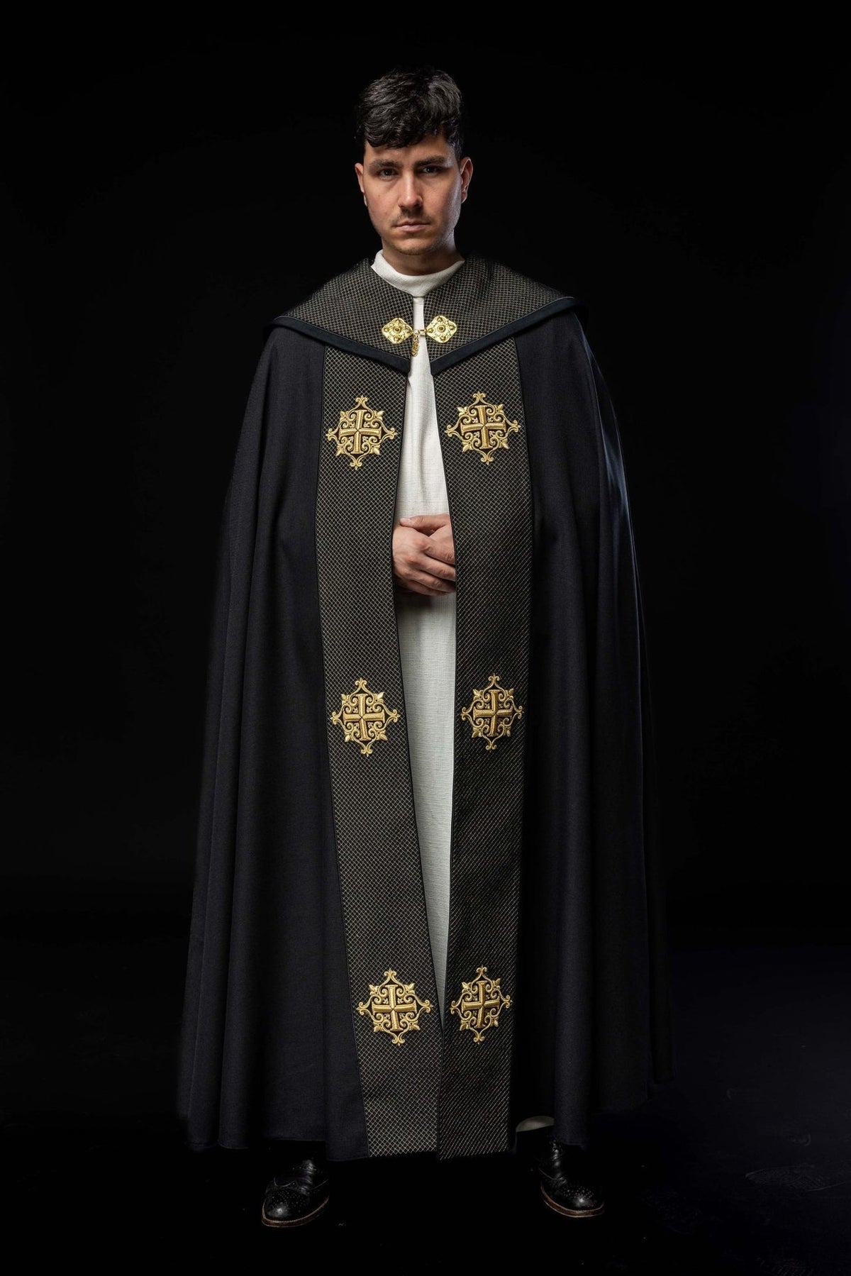 Black velvet cope front view with embroidered gold crosses on the orphrey
