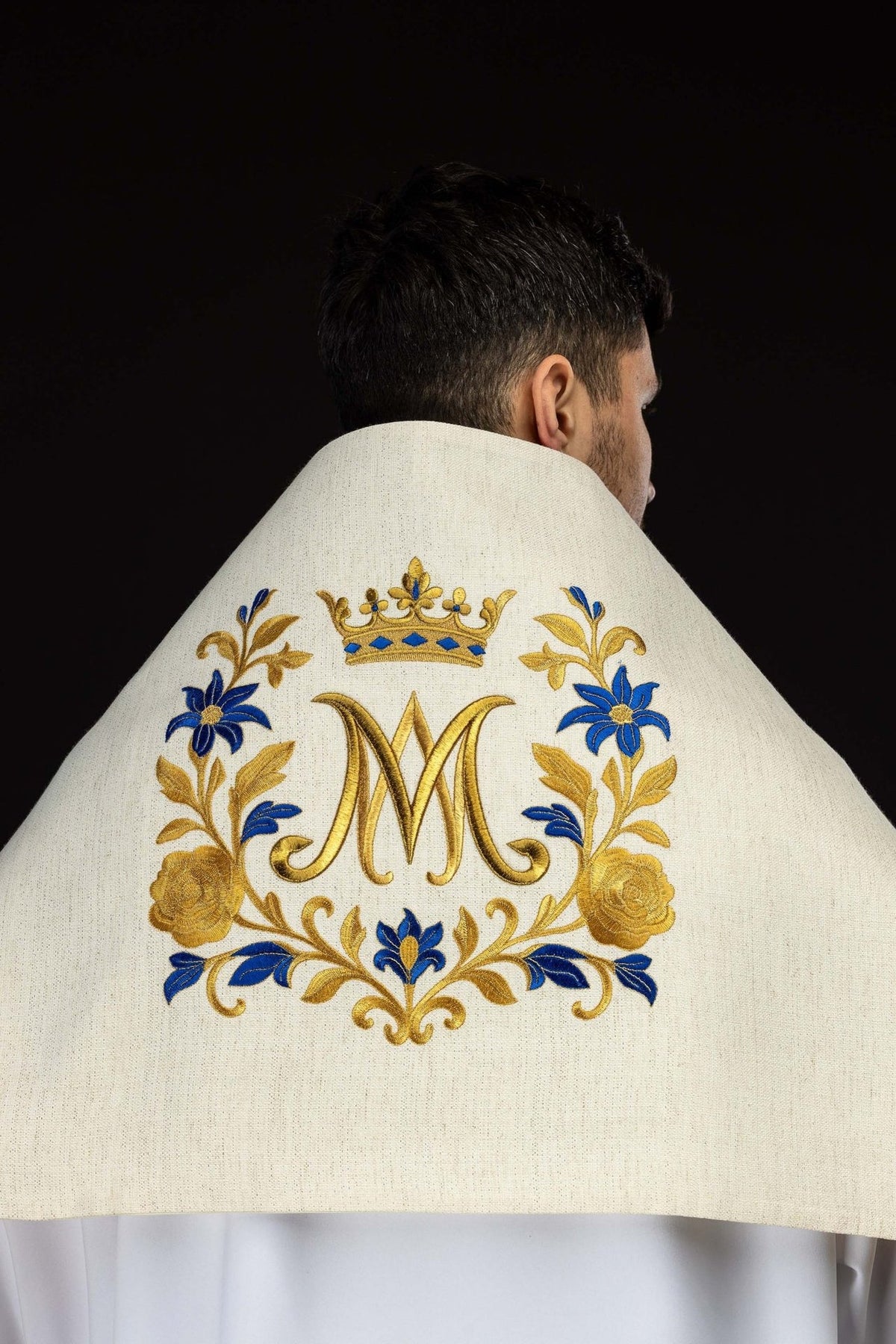 Embroidered humeral veil worn back view with central gold Marian symbol