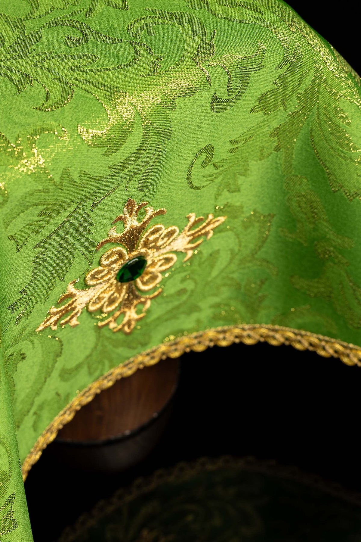 Green chalice veil close-up with embroidered cross motif and gold edging