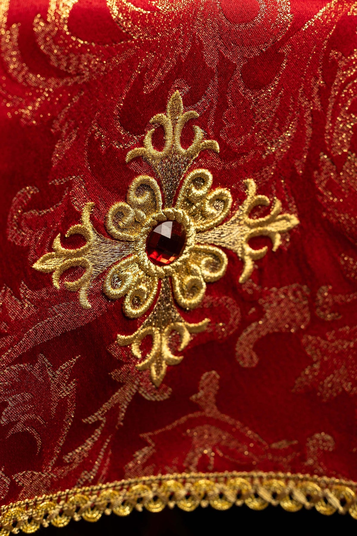 Chalice veil close-up showing embroidered gold cross and red stone