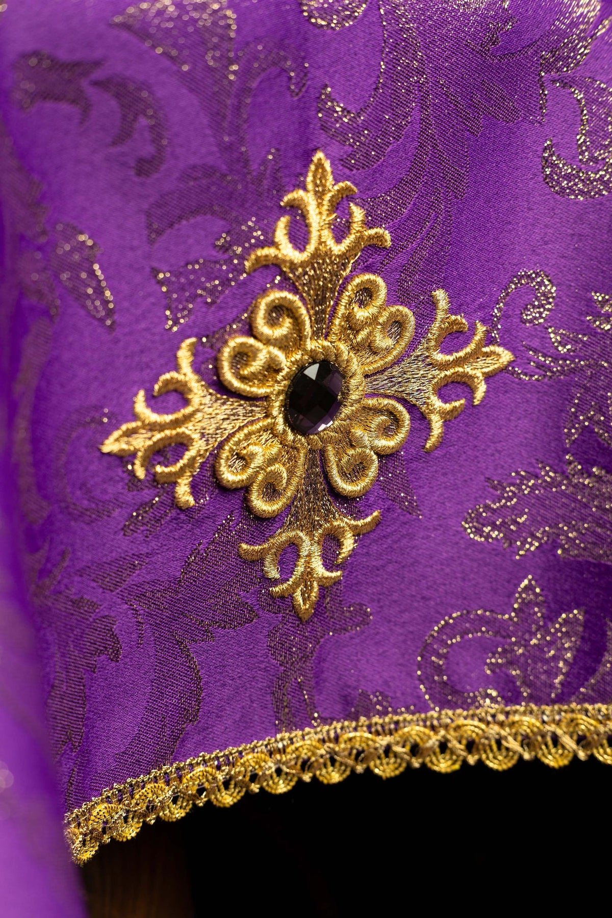 Chalice veil close-up showing embroidered gold cross motif and black stone