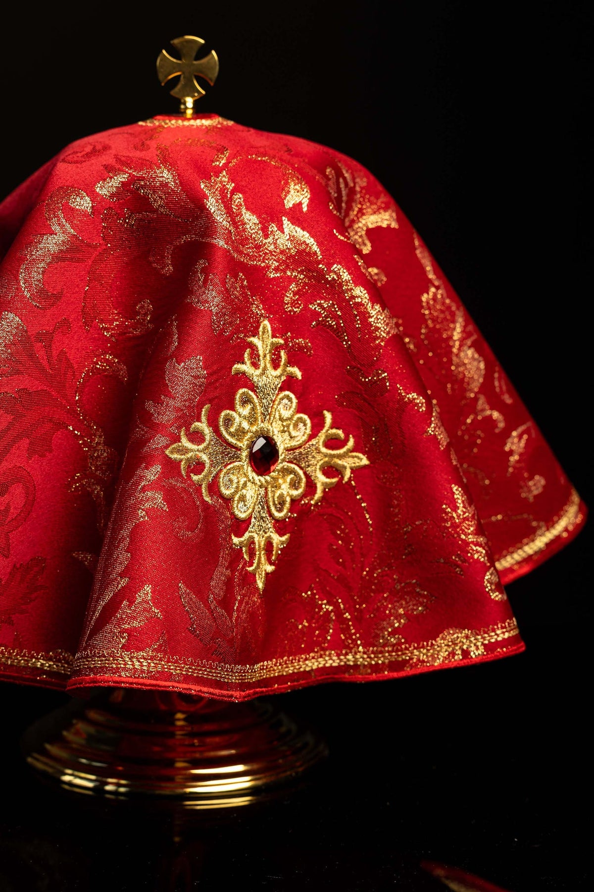 Red ciborium veil angled view with embroidered cross and gold-trimmed edge