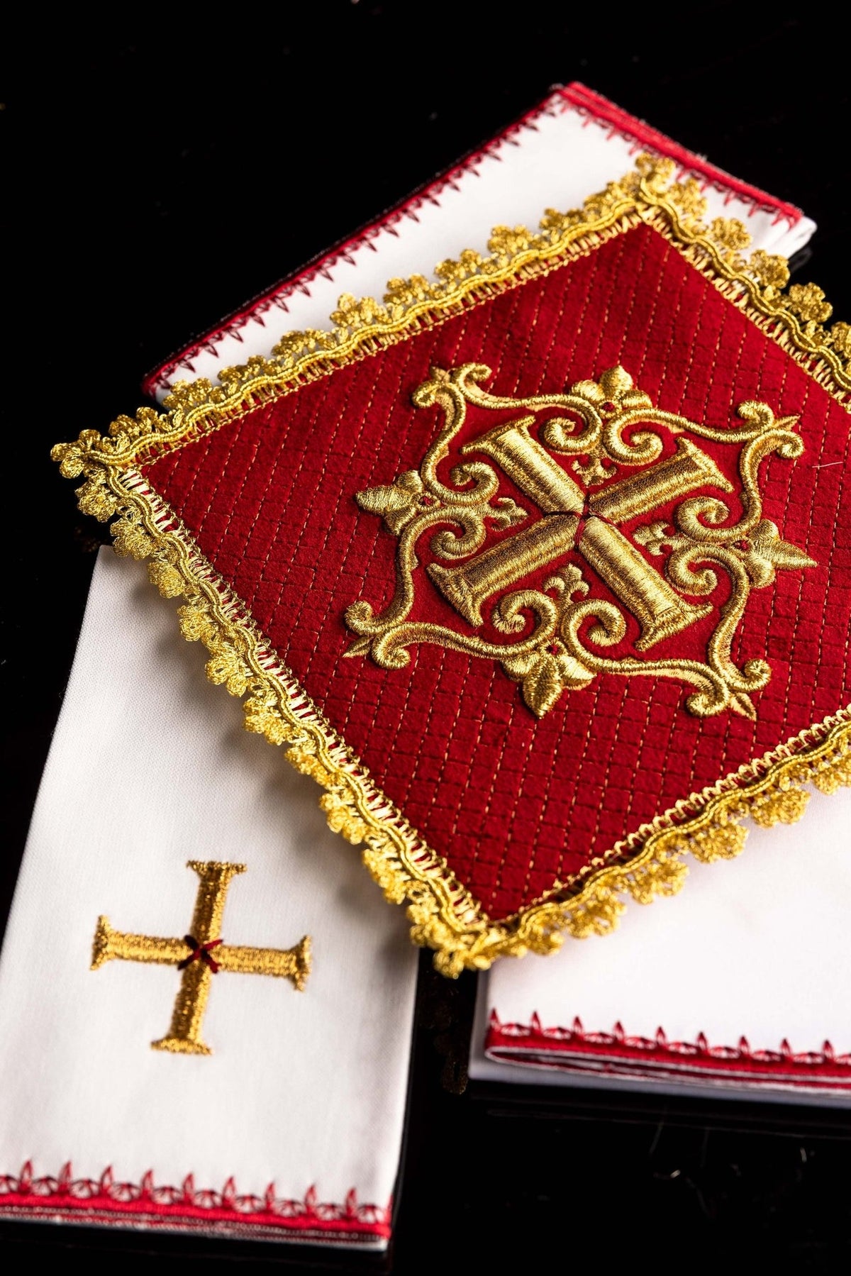 Altar linen set close-up showing white linen with gold cross embroidery and red edging