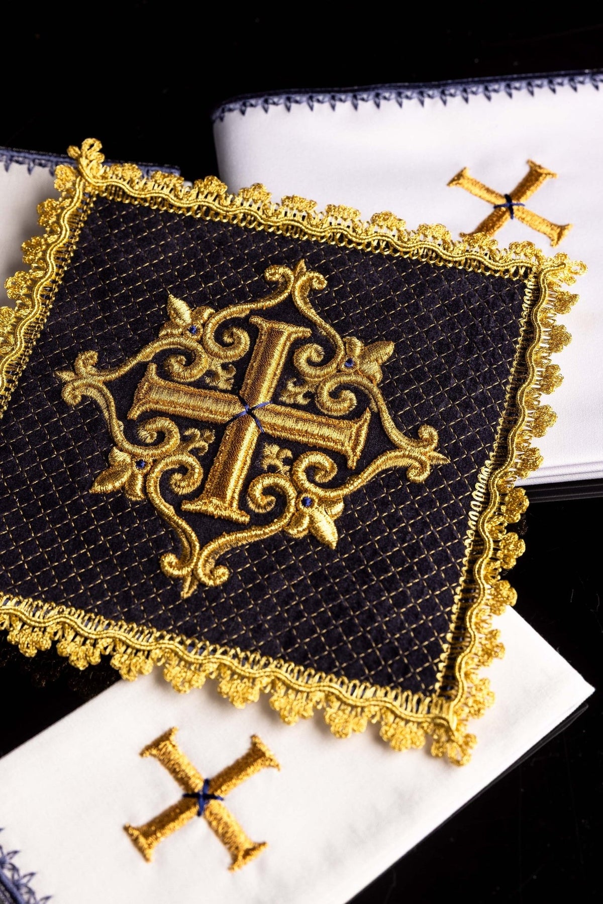 Altar linen set close-up showing purple velvet, gold embroidered cross and ornate gold trim