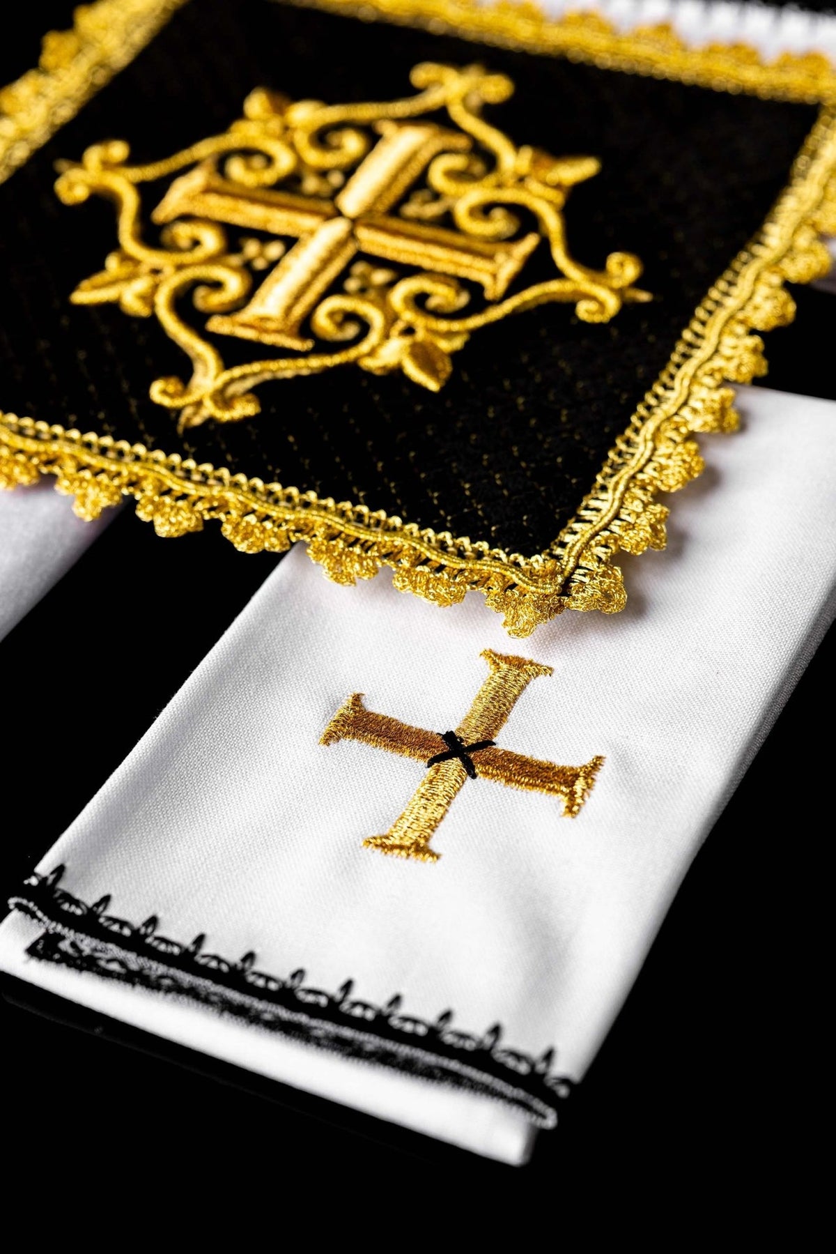 Altar linen set detail showing gold cross embroidery, black edging and white fabric