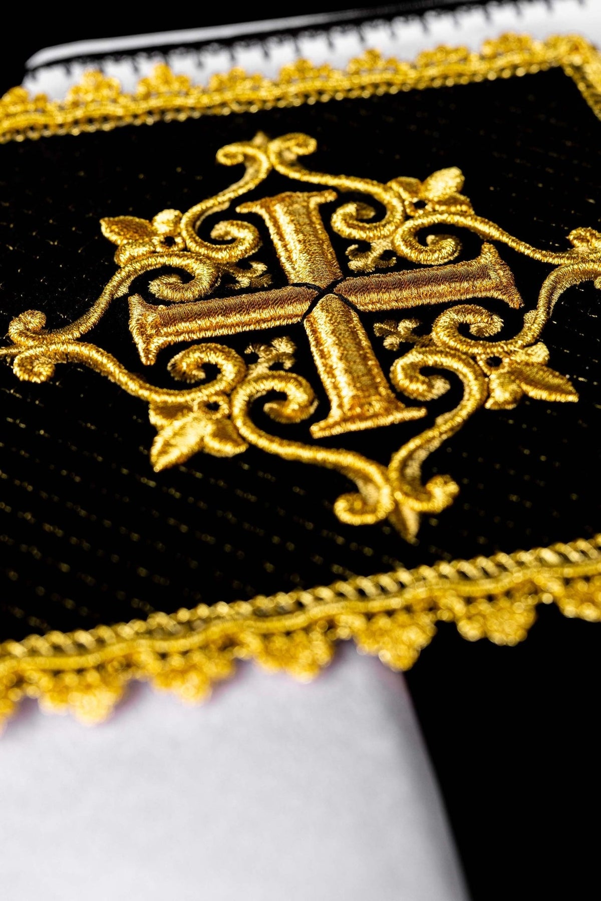 Black velvet panel close-up with large gold embroidered cross and ornate gold border