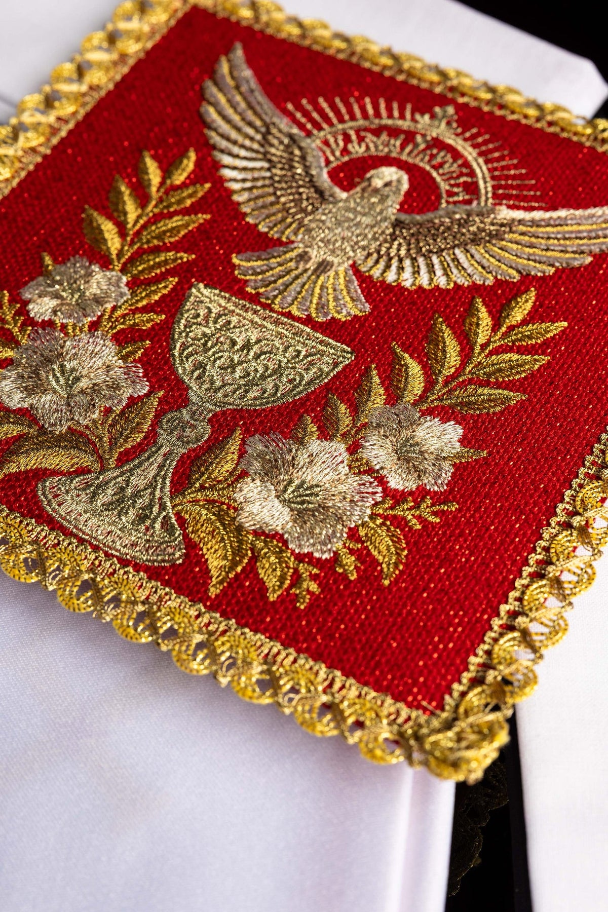 Red altar linen set close-up showing embroidered Holy Spirit and ornate gold border