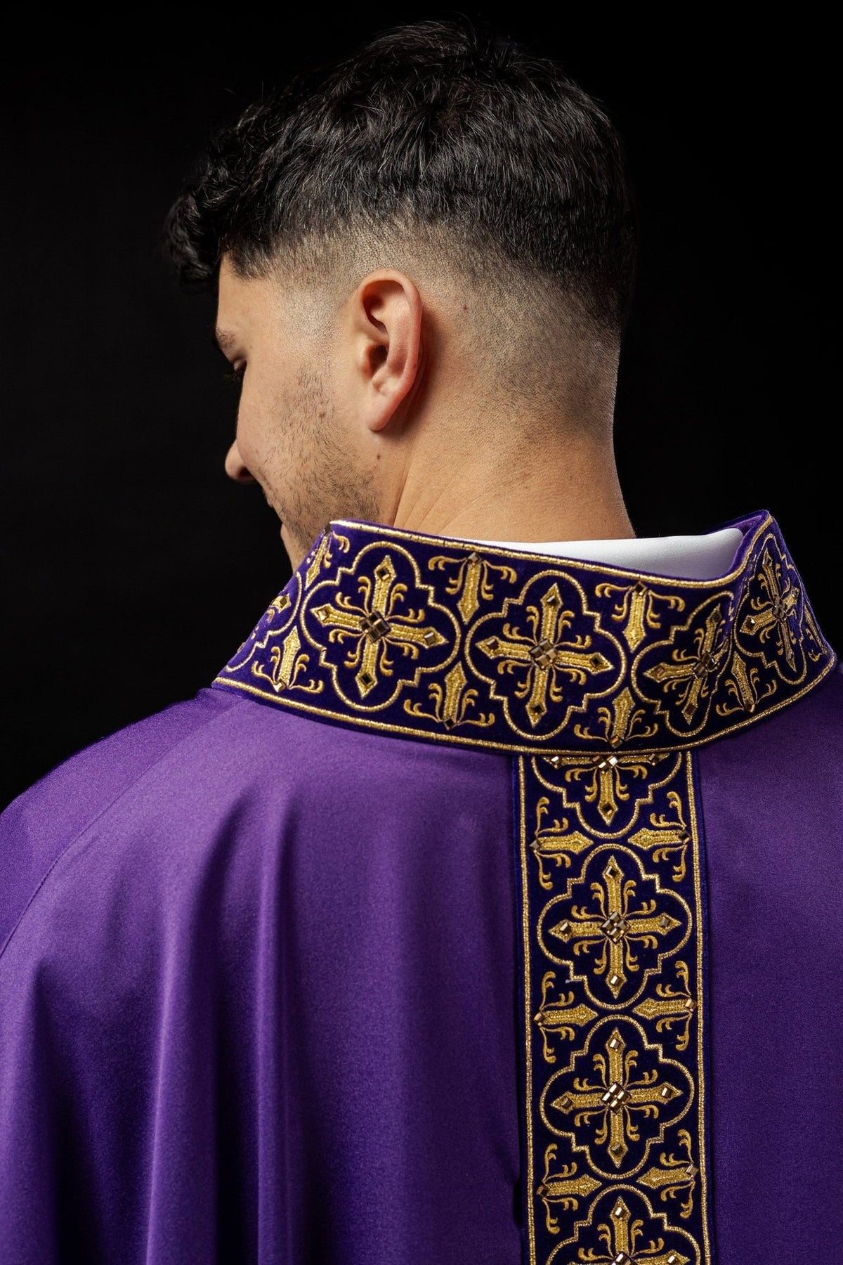 Purple chasuble front detail showing embroidered cross orphrey and wide sleeves