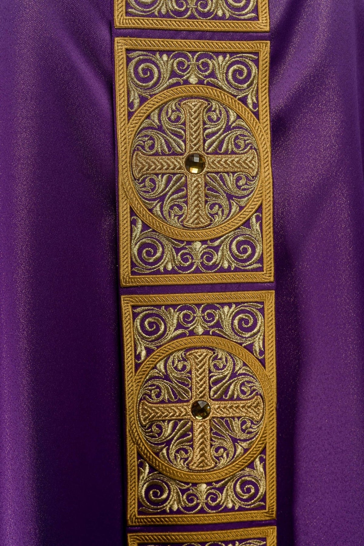 Purple chasuble detail showing embroidered orphrey and faceted stone