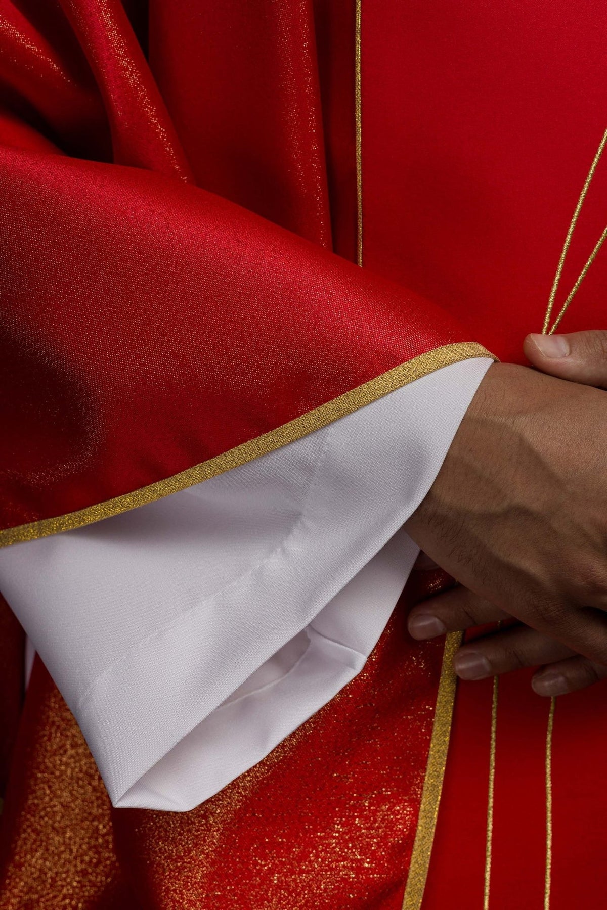 Red chasuble front showing gold embroidery lines and trimmed sleeves