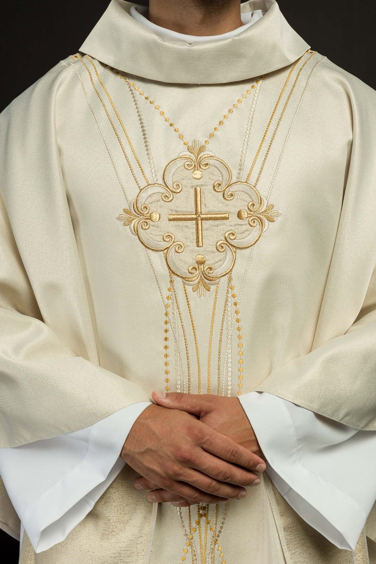 Ecru chasuble close-up showing stand-up collar, gold cross and bead-like embroidery