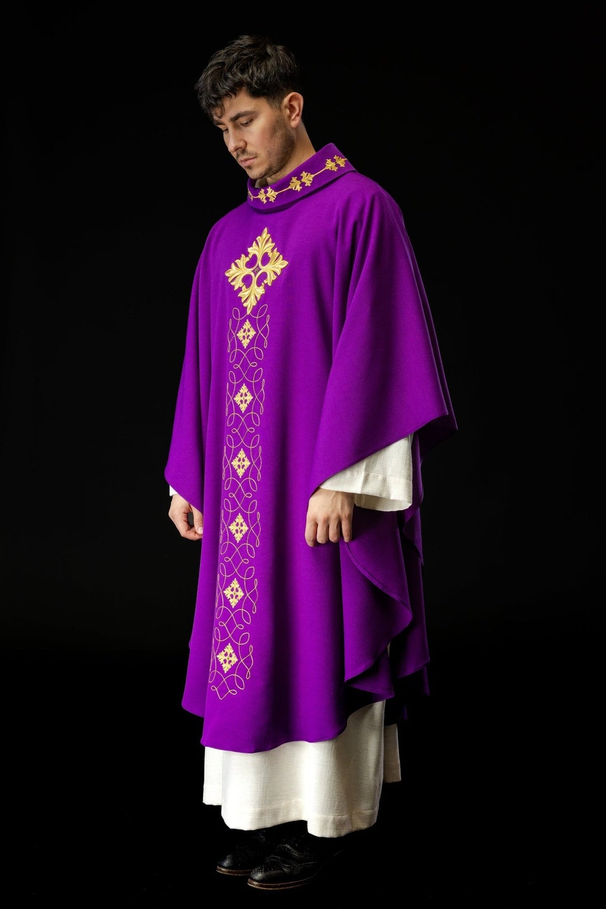 Purple chasuble worn from the front, showing its gold embroidered vertical motifs