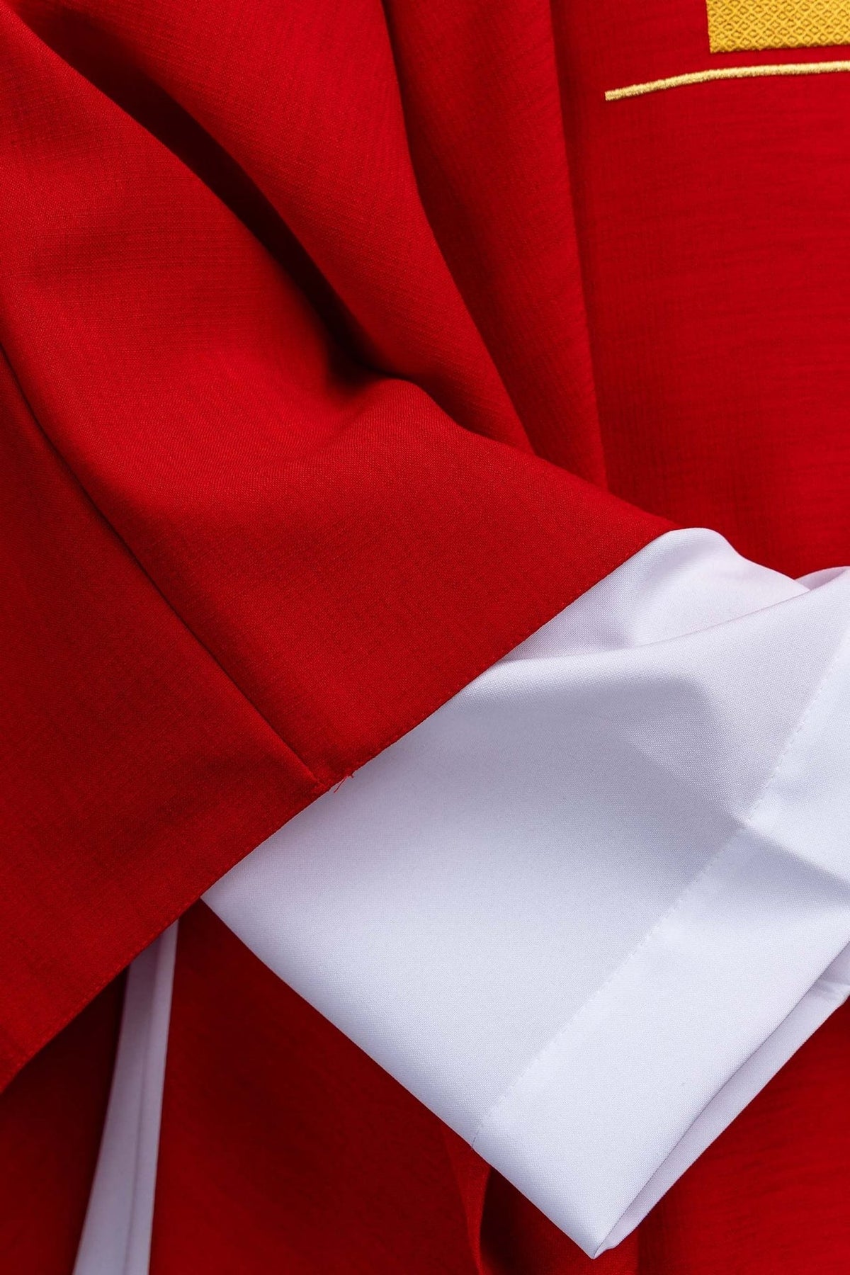 Red chasuble detail showing red fabric and white sleeve lining