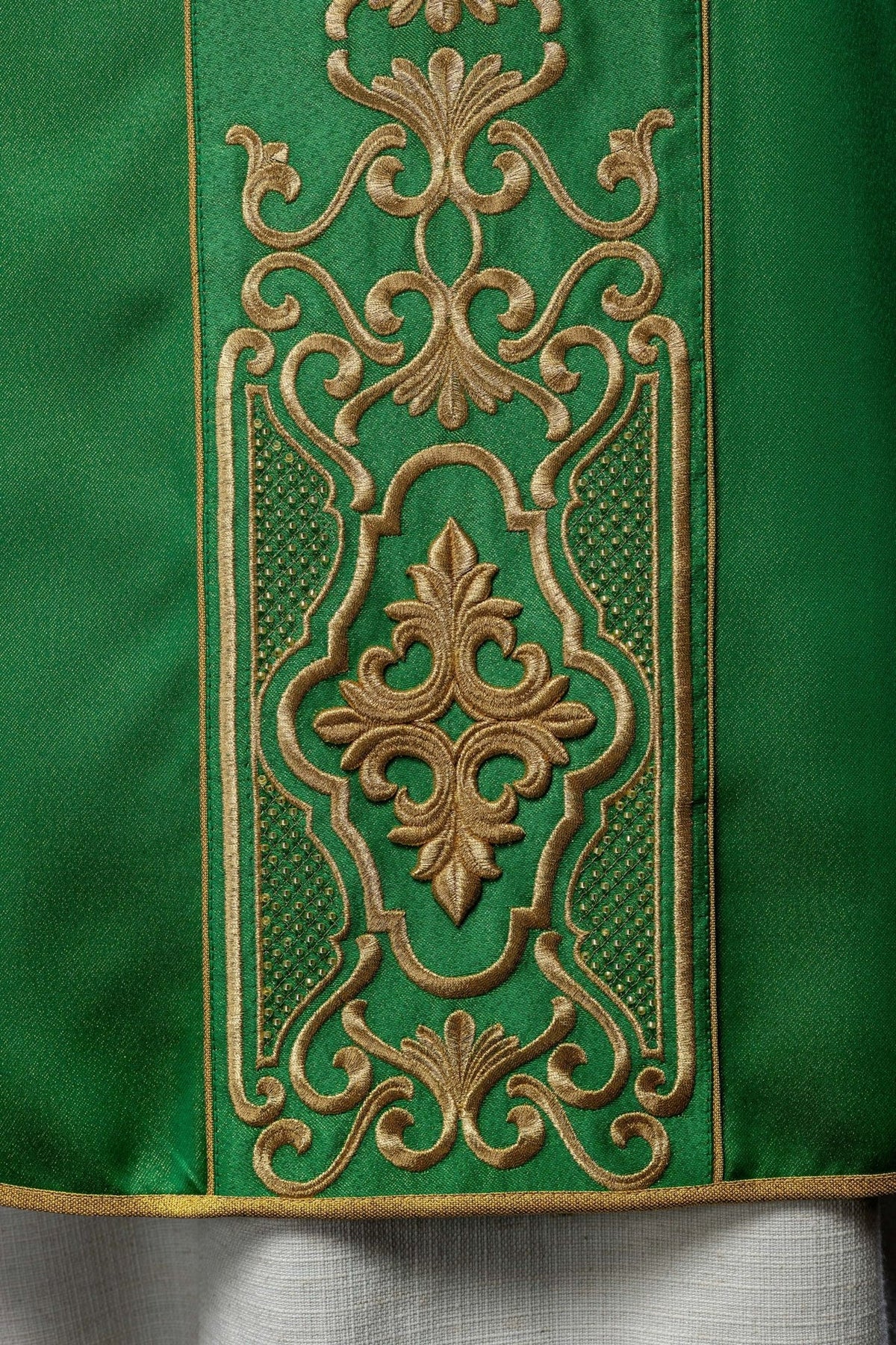 Green chasuble detail showing gold trim and embroidery beside the sleeve