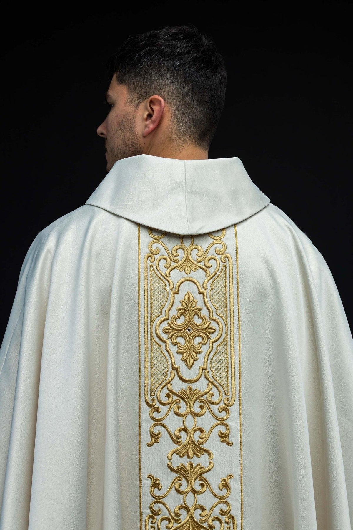 White chasuble back view showing gold embroidered orphrey and stand-up collar
