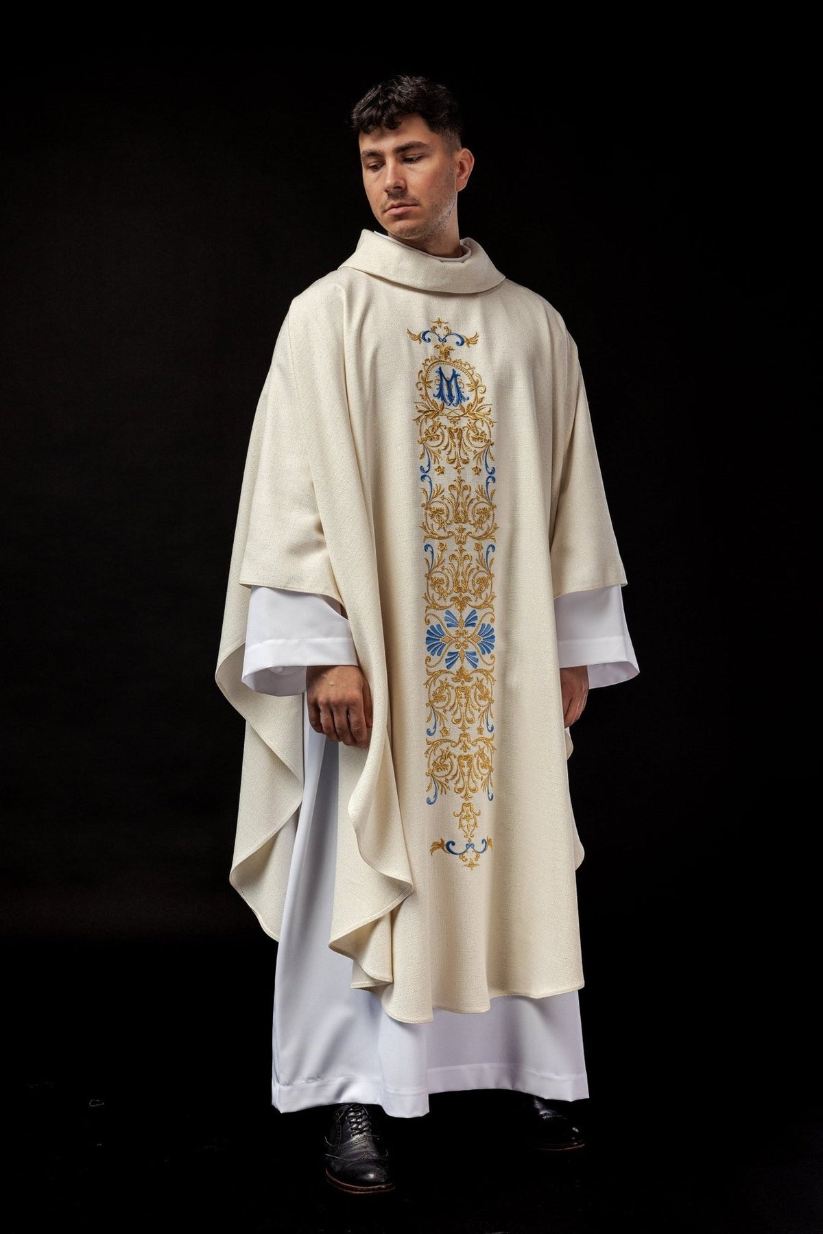 Ivory chasuble front view with flowing shape and blue and gold embroidered panel