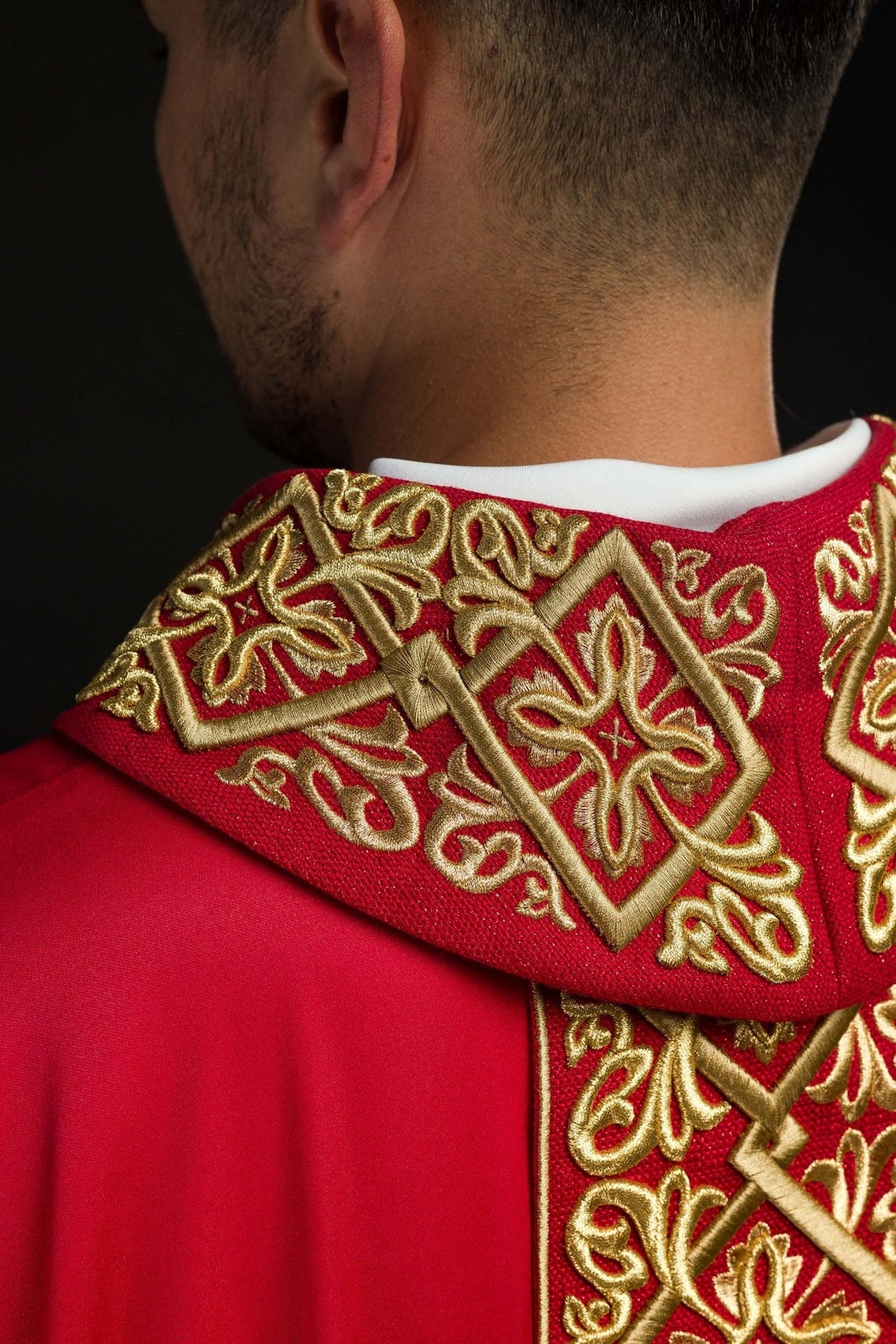 Red chasuble close-up of embroidered gold stand-up collar and floral cross motif at the back