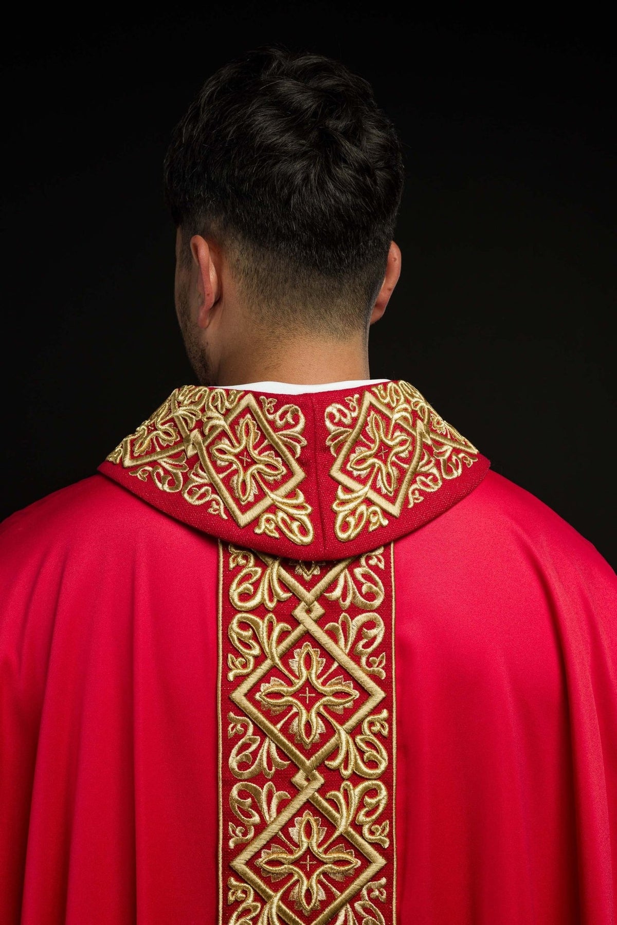 Red chasuble back view with gold embroidered panel, floral motifs and trim