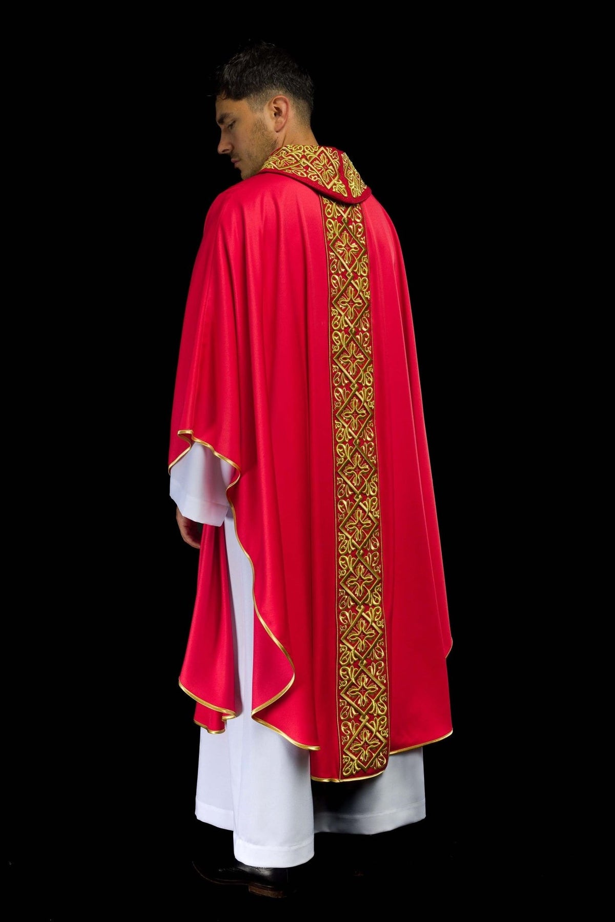 Red chasuble side view showing flowing red satin fabric and gold embroidered back panel