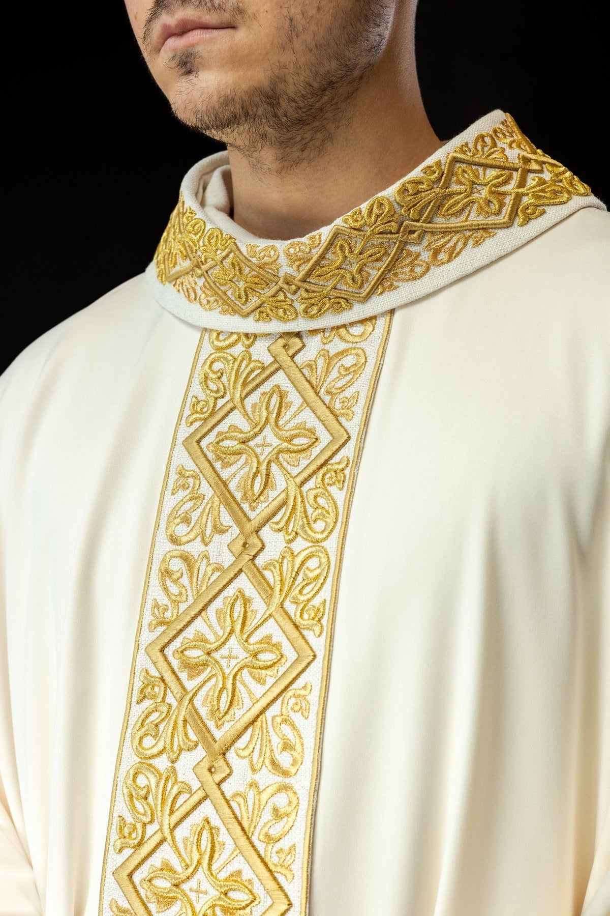 Ecru chasuble close-up showing gold floral embroidery on the stand-up collar