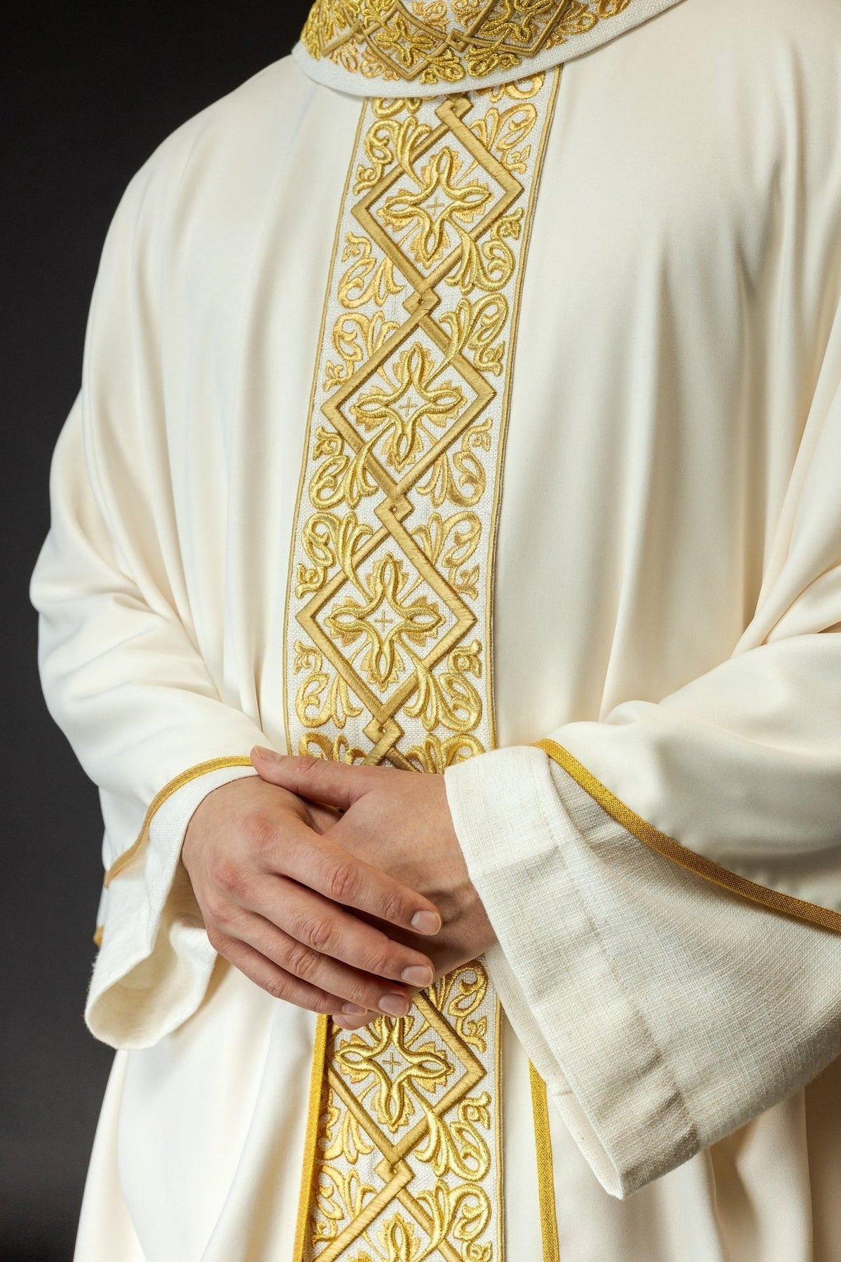 Ecru chasuble detail showing repeated gold cross embroidery