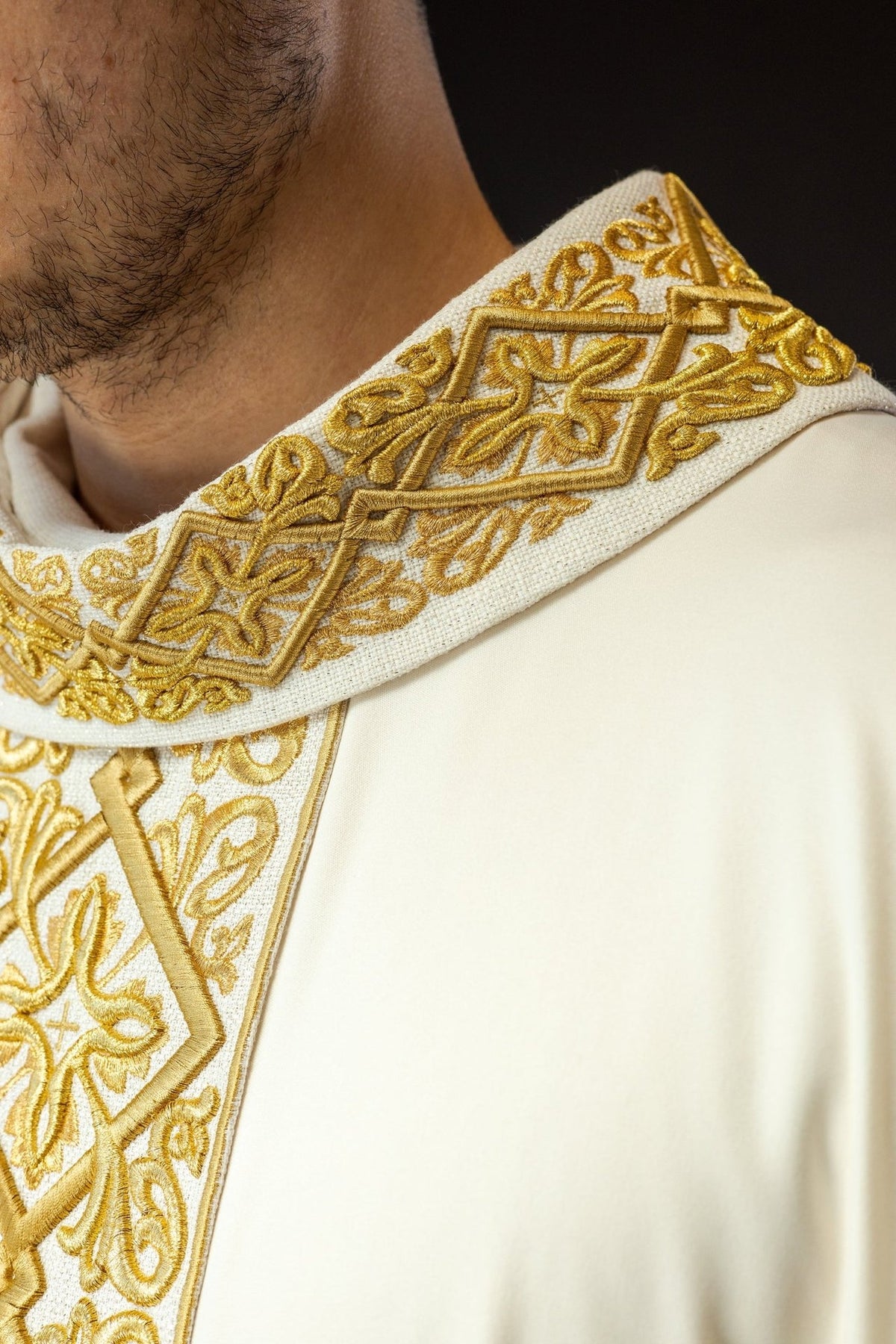 Ecru chasuble front detail with gold embroidered trim and sleeve edge