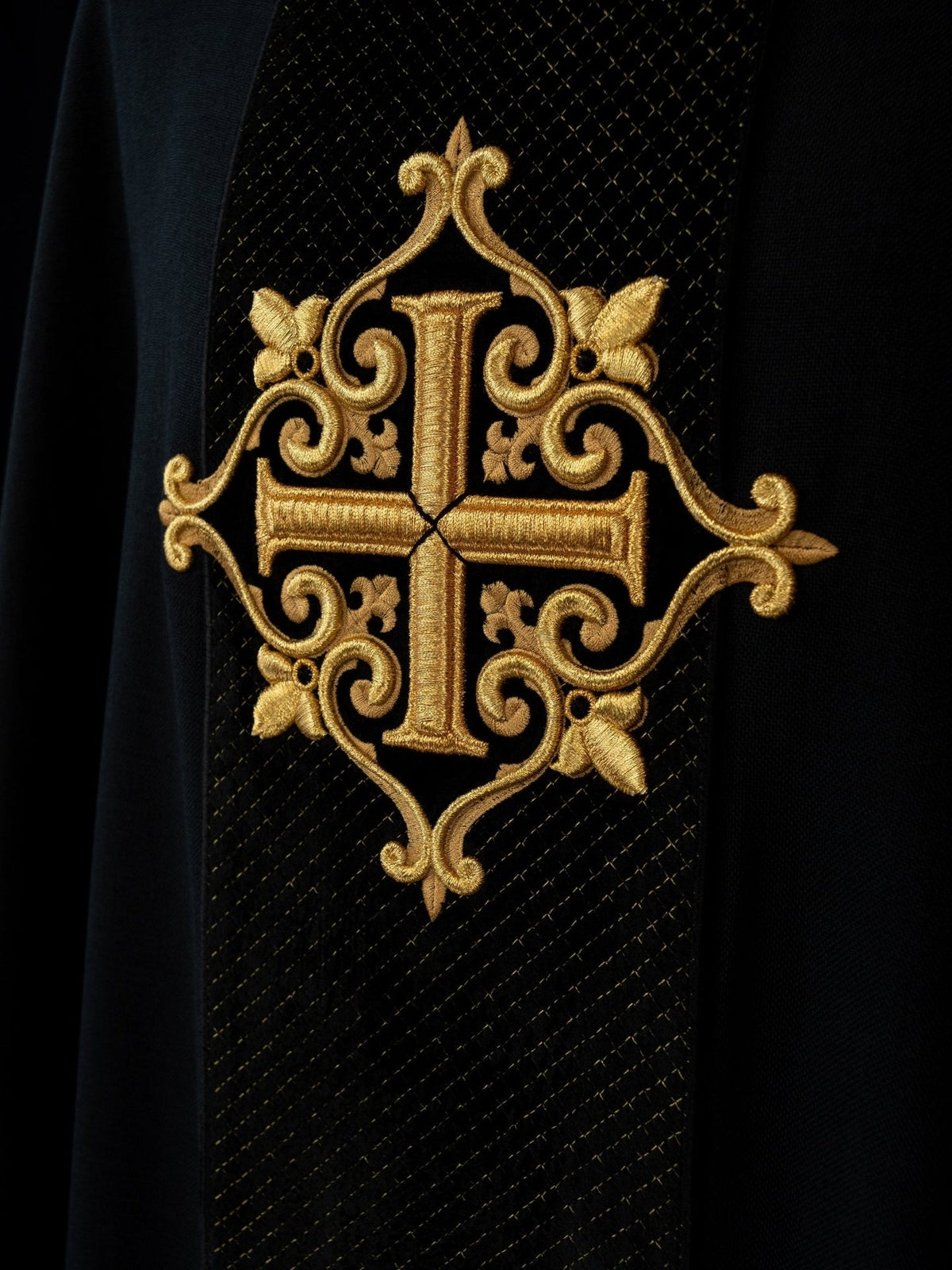 Black velvet chasuble close-up of ornate gold cross embroidery on the front