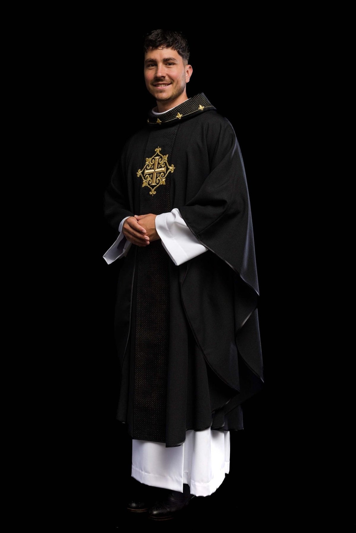 Black velvet chasuble worn in side view with embroidered cross and flowing sleeves