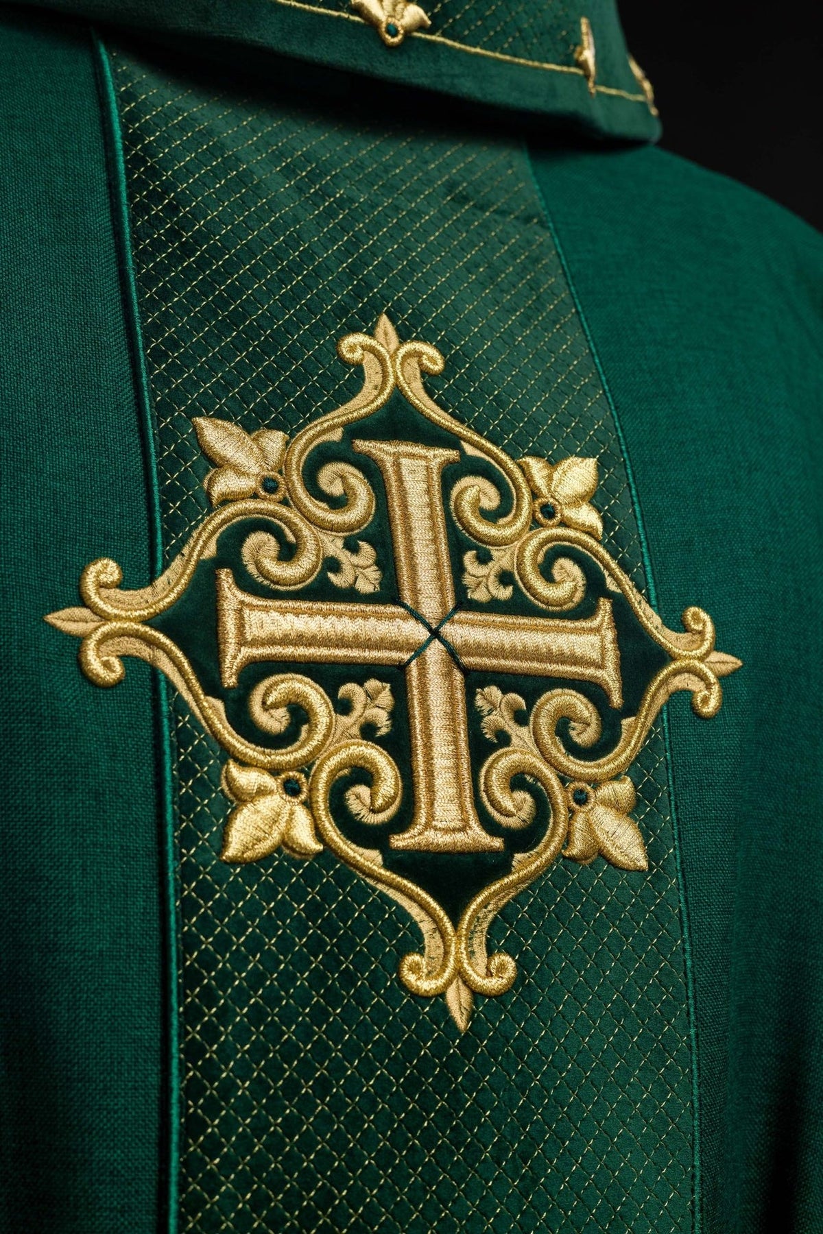 Close-up of green velvet orphrey with ornate gold cross embroidery