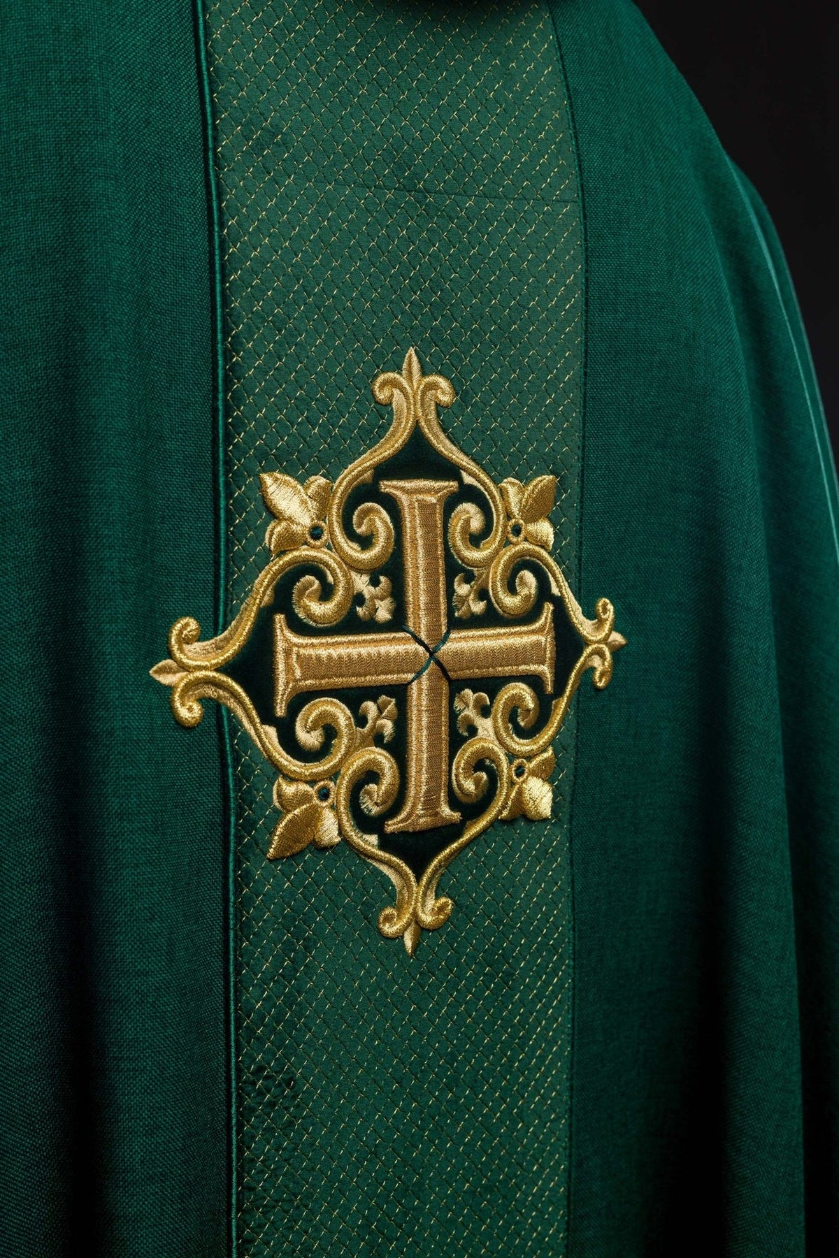 Close-up of green velvet orphrey with ornate gold cross embroidery on the back