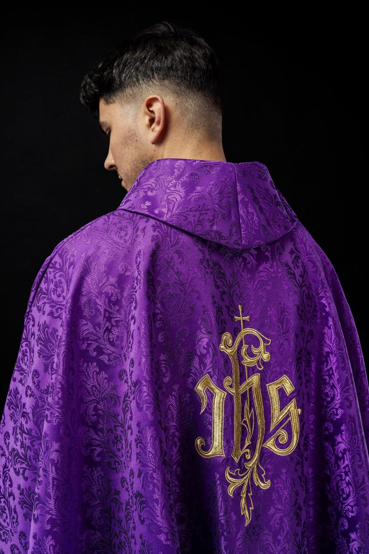 Purple chasuble back view with embroidered IHS motif and gold trim