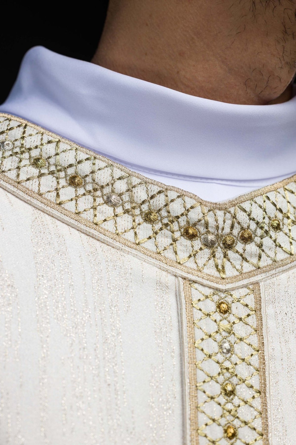 White chasuble sleeve close-up with subtle vertical weave