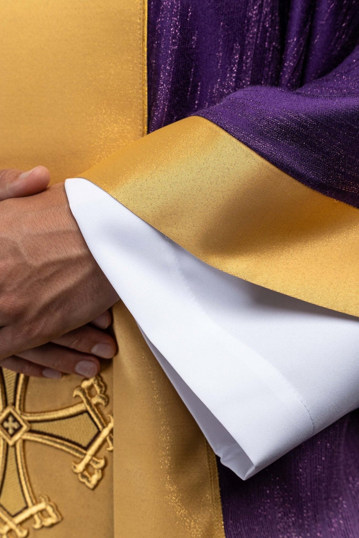 Purple chasuble close-up showing embroidered gold cross on the orphrey