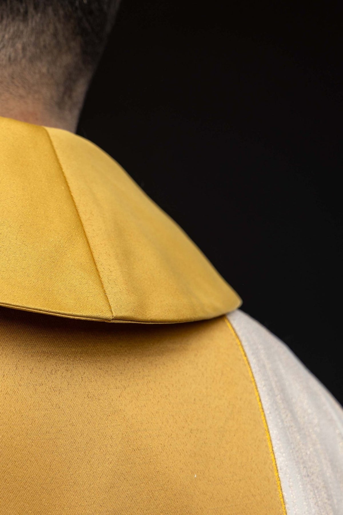 Ecru chasuble close-up showing the gold stand-up collar and orphrey