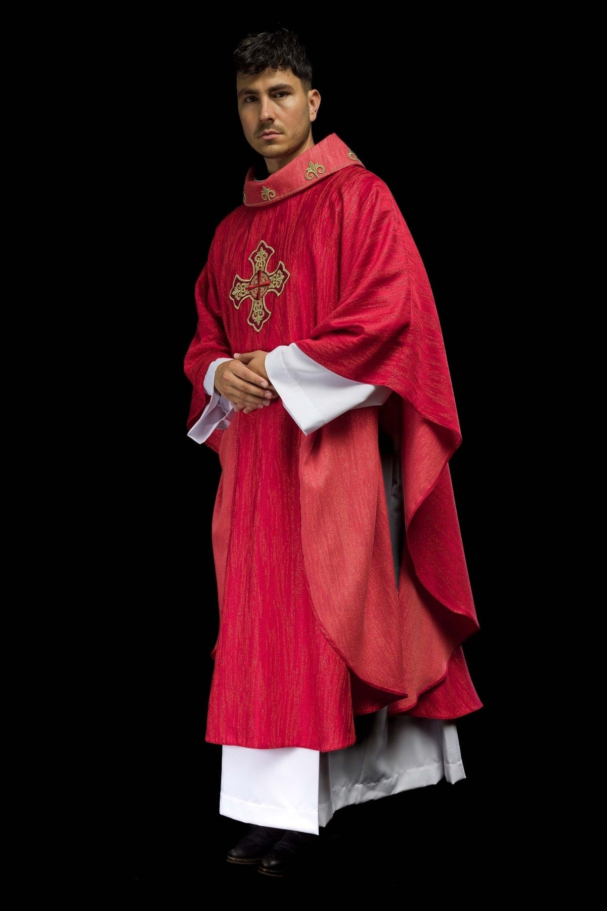 Red chasuble three-quarter view showing flowing shape and embroidered cross