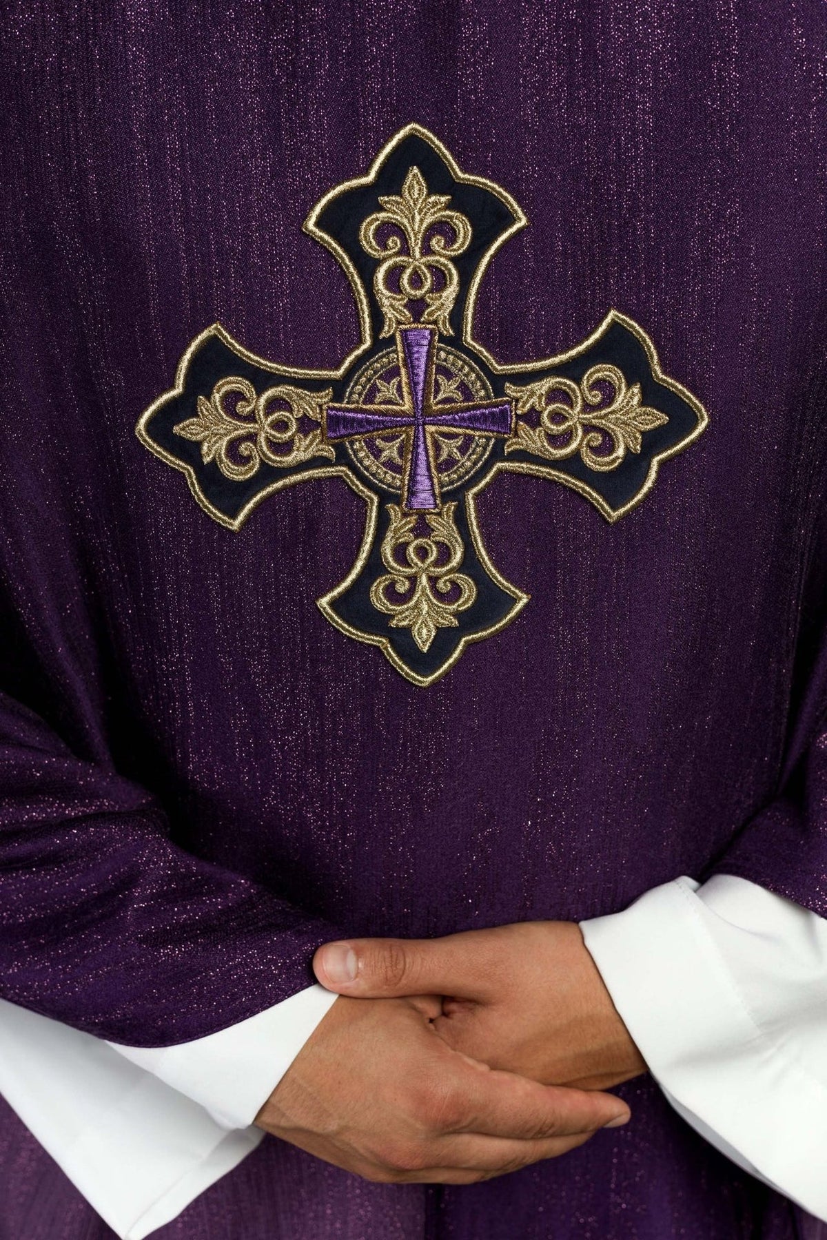 Purple chasuble close-up showing embroidered gold cross motif