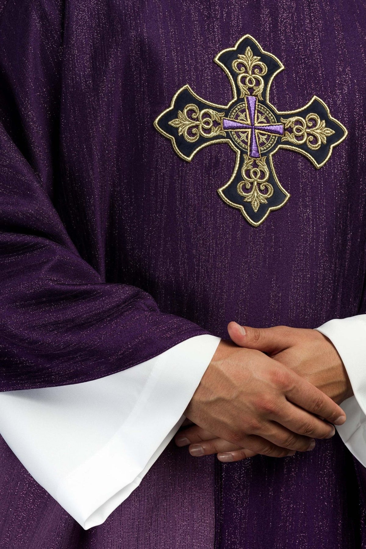 Purple chasuble close-up showing cross embroidery and decorative fabric