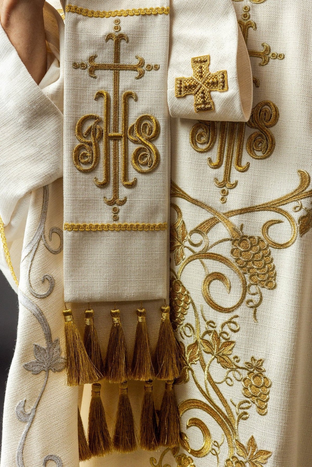 Ecru chasuble detail with gold trim and embroidered grape motifs